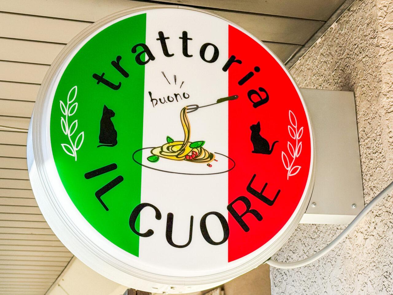 trattoria IL CUOREのトリコローレ丸看板、黒猫2匹とbuonoの手書き文字